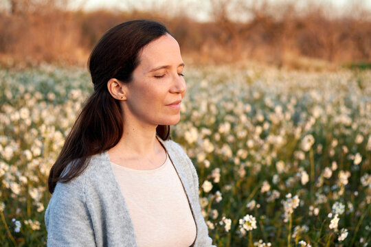 woman meditating among flowers mindfulness concept