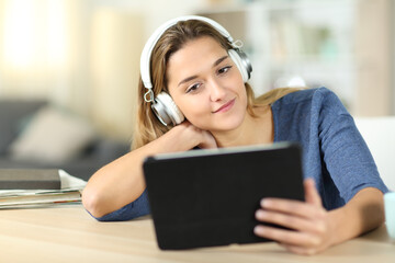 Woman watching media on tablet wearing headphones