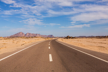 Naklejka premium Road in the sahara desert of Egypt. Conceptual for freedom, enjoying the journey. Empty road. Freeway, Highway through the desert