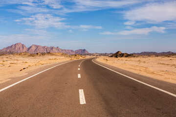 Fototapeta na wymiar Road in the sahara desert of Egypt. Conceptual for freedom, enjoying the journey. Empty road. Freeway, Highway through the desert