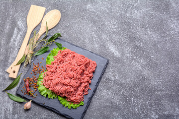 Fresh minced pork and beef, garnished with garlic, red pepper and dill on a slate stone.Dark...