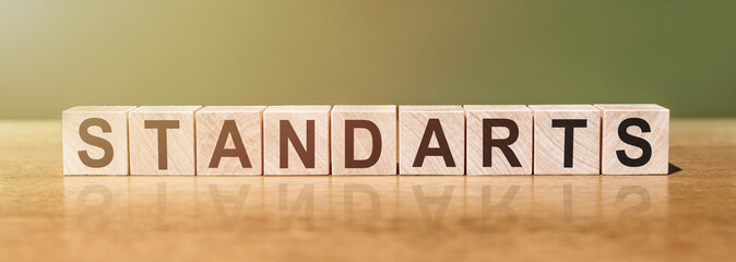 STANDARTS word written on wooden blocks on wooden table. Concept for your design.