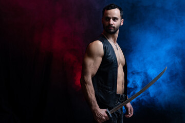 Fototapeta na wymiar Muscular Man posing with long sword isolated on black and smoked background