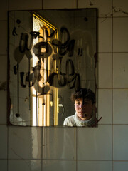 Young woman in a mirror of an abandoned house