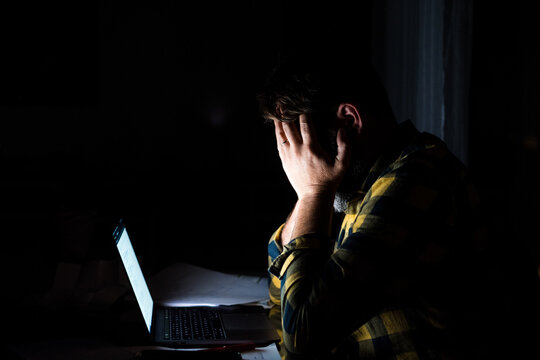 Tired and frustration man working and using laptop at late night. Business man upset to have work too much .