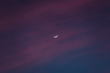 Atadecer con nubes rosadas y luna creciente