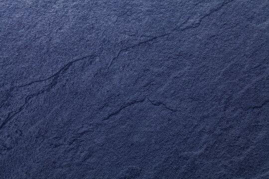 Navy blue background of natural slate. Texture of stone closeup.