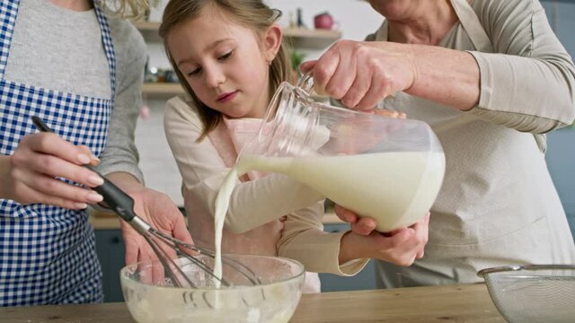 Video of little girl helping and pouring milk for bowl. Shot with RED helium camera in 8K.