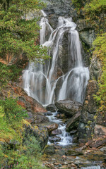 Fototapeta na wymiar Picturesque waterfall in the wild mountains of Siberia