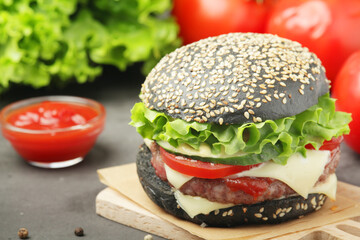 A black burger with vegetables and beef meat	