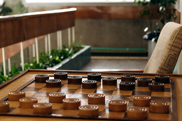Recreation area with checkers on the table and indoor plants.Home gardening.Houseplants and urban jungle concept.Biophilia design.Selective focus with shallow depth of field.