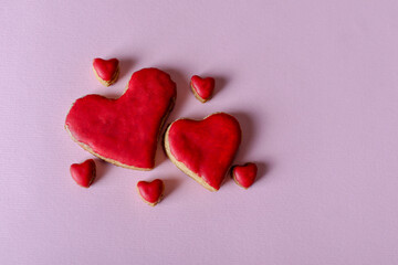 Homemade red cookies in the shape of a heart isolated on purple background with copy space for text or design. Valentines day and love concept