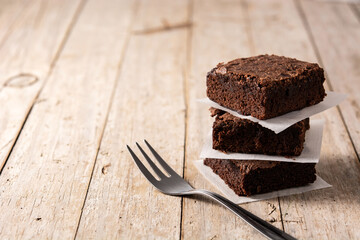 Homemade pieces of brownies on wooden table. Copy space