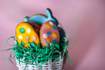 Easter cookies in the shape of a rabbit and colorful eggs isolated on pink background. Easter holiday concept food decoration