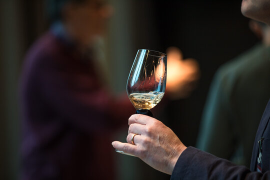 Close Up On A Hand Holding A Glass Of White Wine