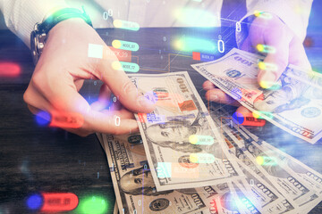 Double exposure of technology drawing hologram and us dollars bills and man hands. Data concept