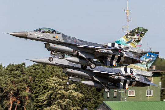 Belgian Air Force F-16 fighter jets in special colors with D-Day invasion stripes taking off from Kleine-Brogel Airbase.