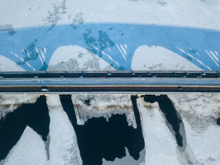 Kyiv metro bridge. A shadow falls on the frozen Dnipro river. Aerial drone view. Winter sunny...