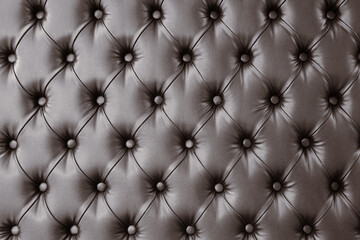 Decorative upholstery of wall with soft interior panels. Wall furniture upholstery in dark brown leather or fabric. Texture.