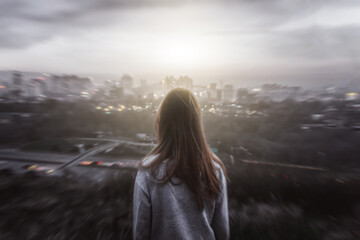 Girl looking from the mountain at the city in horror style