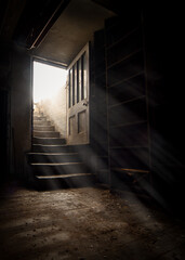 Dark and creepy wooden cellar door open at bottom of old stone stairs bright sun light rays shining...