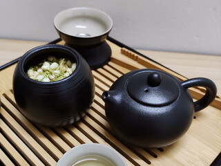 Obraz na płótnie Canvas Chinese traditional tea set for tea ceremony with dried jasmine flowers close up