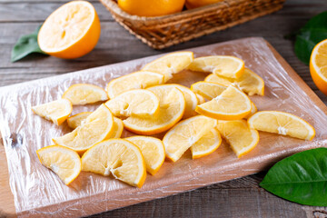 Frozen lemon slices on a cutting board on a wooden table