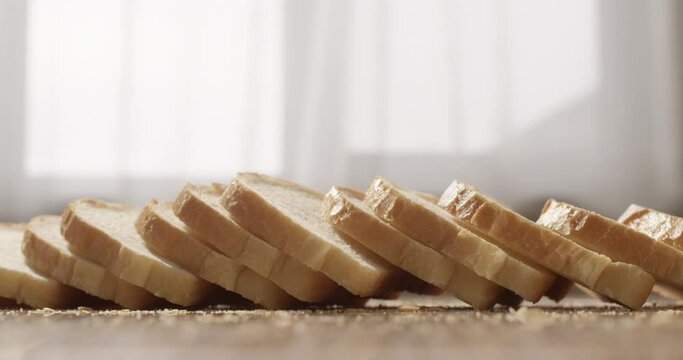 Sliced White Bread Falling on the Table in Slow Motion
