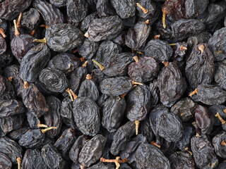 Black dried grapes on a white background