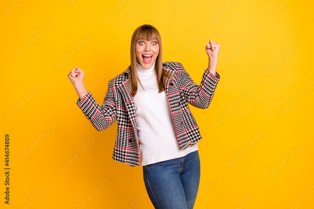 Poster Portrait of impressed funky girl open mouth fists up success wear checkered isolated on yellow color background