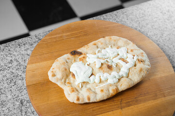 Dough for pinsa romana with cheese sauce. Scrocchiarella gourmet italian cuisine. Traditional dish. Food delivery from pizzeria
