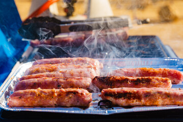 Sausages meat grilling on gas grill