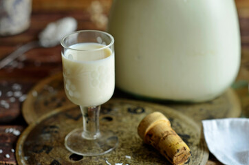 Coconut liqueur in a glass on a rustic background
