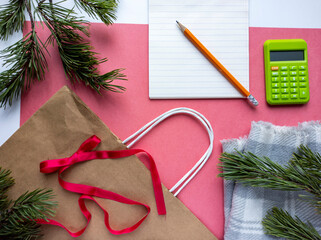 Photo of New Year's flat lei.
Photo top view of coniferous branches, gift bag. Pink background.
