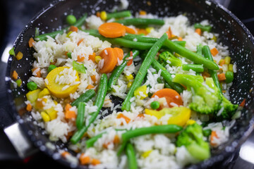 Foiled lined baking sheet filled with raw carrots, cauliflower, brussels sprouts, baby bell peppers coated in oil and spices to be roasted in the oven.