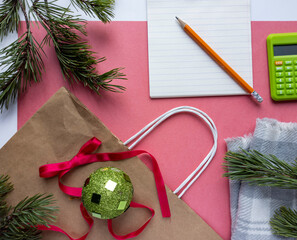 Photo of New Year's flat lei.
Photo top view of coniferous branches, gift bag. Pink background.