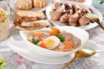 traditional Easter dishes with white borscht and sausage on festive table