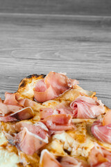 Scrocchiarella with pear, cheese, prosciutto on grey wooden background. Pinsa romana gourmet...