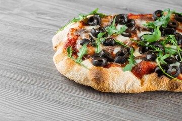 Pinsa romana gourmet italian cuisine on grey wooden background. Scrocchiarella traditional dish....