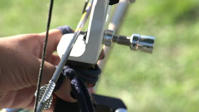 Hands and recurve bow during archery target practice, close up slow motion shot