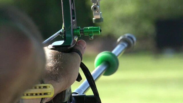 Aiming and shooting a recurve bow, archery target practice, close up slow motion shot