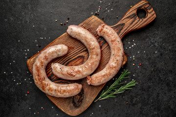 grilled sausages with spices on a stone background