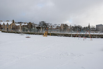 The frozen playground and tennis court at meadows during the winter covered by snow in Edinburgh, Scotland