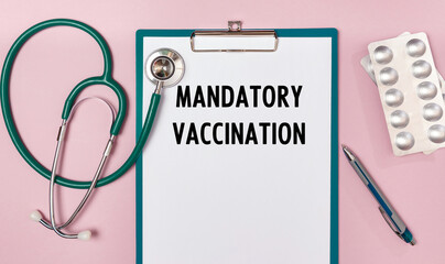 Worksheet with the inscription Mandatory Vaccination, stethoscope and pills