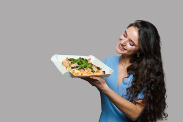 Girl courier with pinsa romana gourmet italian cuisine on grey background. Holding scrocchiarella...