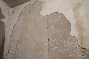 Wall with plaster partially removed.