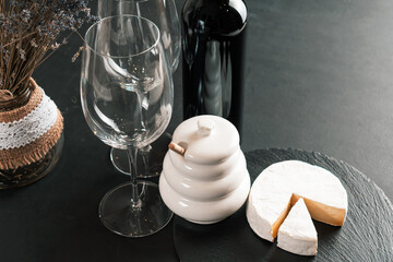 Wine glasses, bottle of red wine and black board with camembert cheese