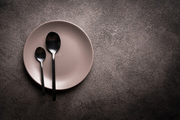 a gray plate and spoons on a black table. copyspace concept for advertising dishes or restaurant...