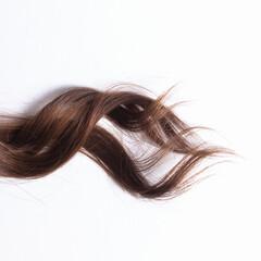 Naklejka premium a lock of natural brunette hair on a white background