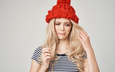 emotional blonde woman in striped t-shirt with cap on her head on phone cropped view